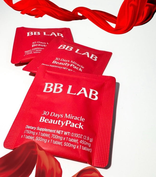 Три червоних саше колагену BB LAB 30 Days Miracle BeautyPack поряд з червоними платочками на білому фоні.