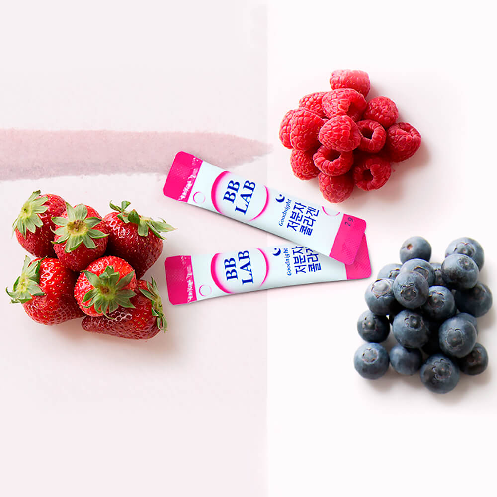 Два саше колагену BB Lab Good Night Collagen лежать в оточенні малини, чорниці та полуниці.
