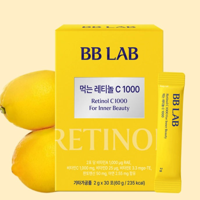 Жовта коробка з жовтим саше Ретинолу з колагеном BB LAB Retinol C 1000 стоїть на жовтому фоні поряд з лимоном.