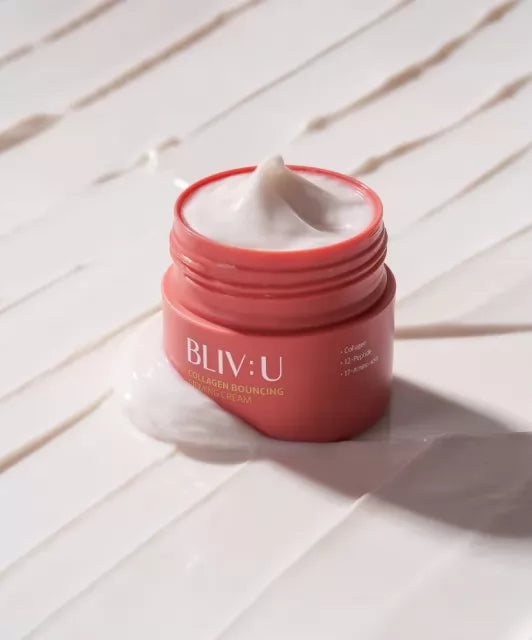 Відкрита баночка BLIV:U Collagen Bouncing Firming Cream 80 мл кольору грейпфрута стоїть на білій кремовій поверхні